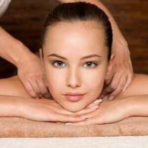 mujer relajada recibiendo tratamiento facial en spa con expresión de bienestar y tranquilidad sobre camilla de masaje