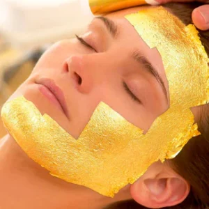 mujer recibiendo tratamiento facial de 24 kilates con mascarilla de oro aplicada en rostro para rejuvenecimiento y luminosidad premium