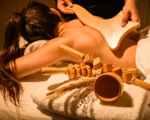 terapeuta aplicando maderoterapia con copa sueca de madera en la espalda para masaje descontracturante y relajante