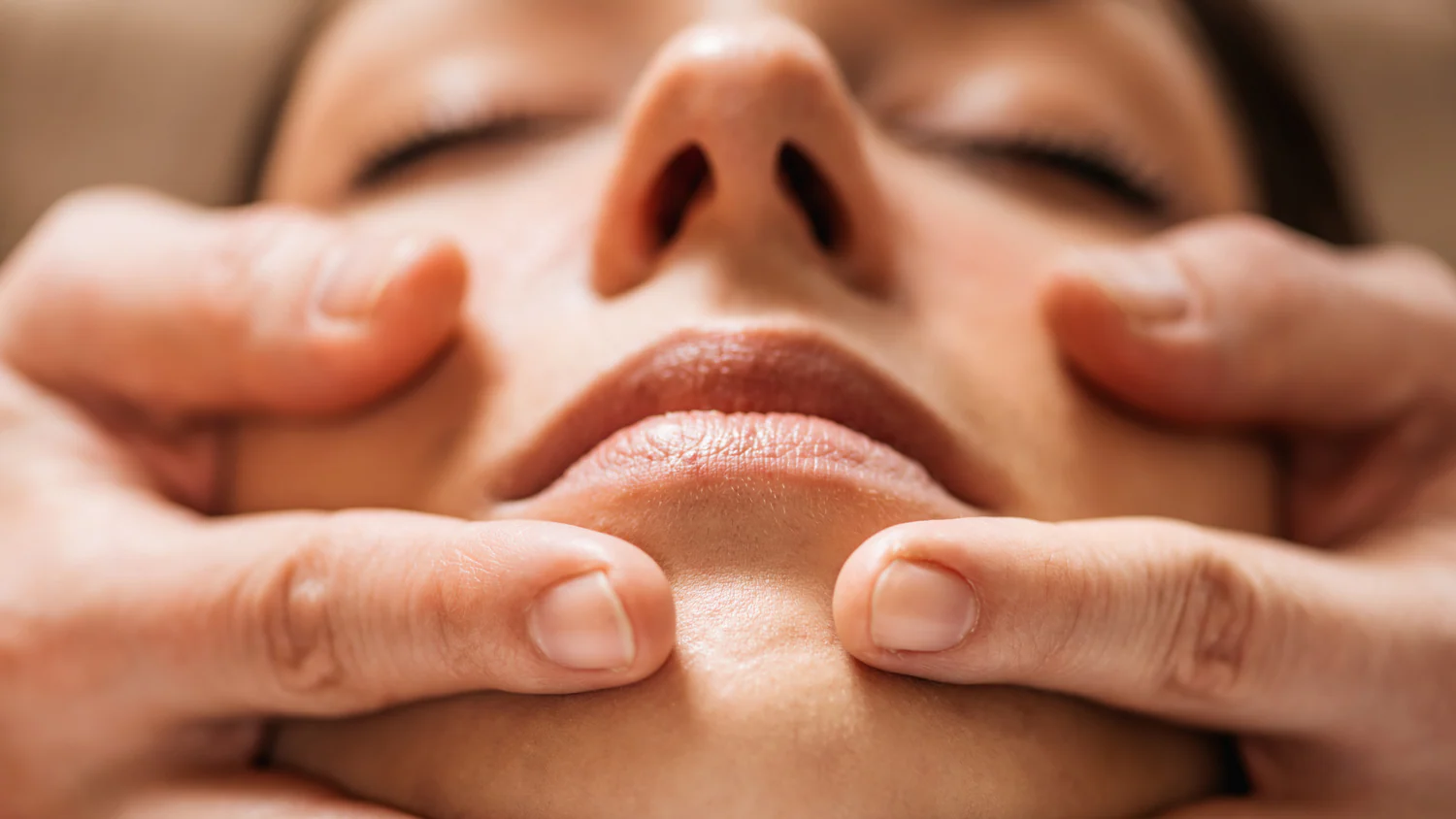 Masaje facial en mujer con técnicas profesionales para rejuvenecimiento y relajación