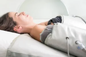 mujer relajada recibiendo tratamiento de presoterapia en brazos con mangas de compresión neumática en ambiente spa tranquilo