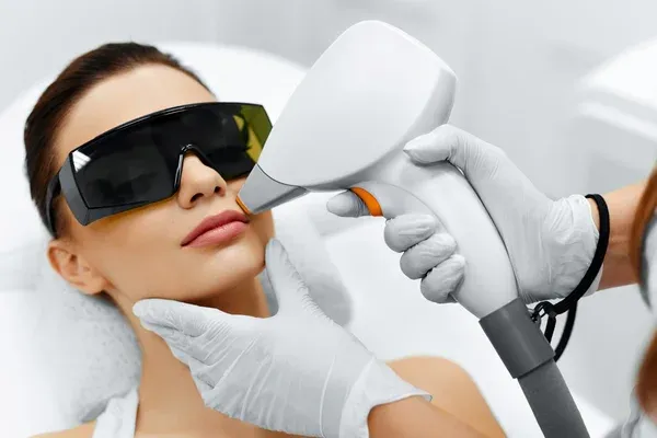 Depilación láser facial en mujer con gafas de protección y tecnología avanzada