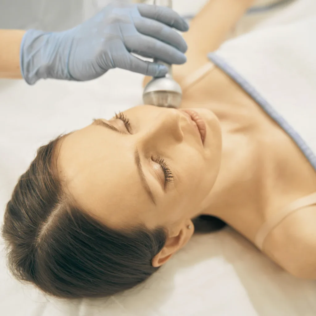 esteticista aplicando tratamiento tensor facial con tecnología profesional en rostro de mujer para reafirmar y rejuvenecer la piel