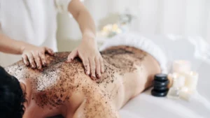mujer relajada recibiendo peeling corporal en spa con masaje