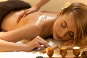 mujer relajada recibiendo peeling corporal en spa con expresión de bienestar y tranquilidad durante el tratamiento