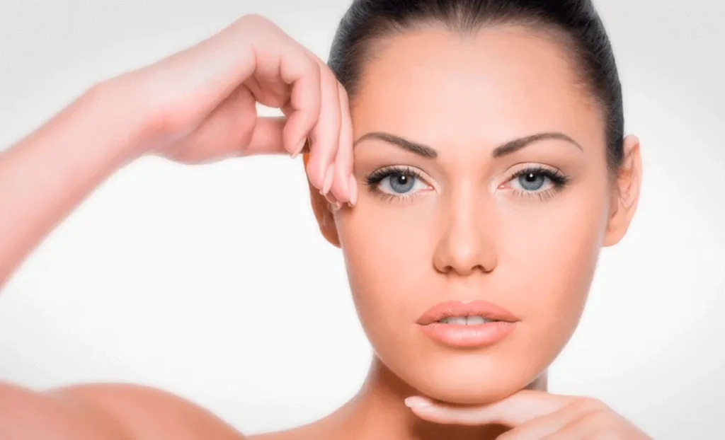 mujer mostrando rostro con piel firme y rejuvenecida tras peeling facial en Murcia, tocando zona del contorno facial con resultado visible