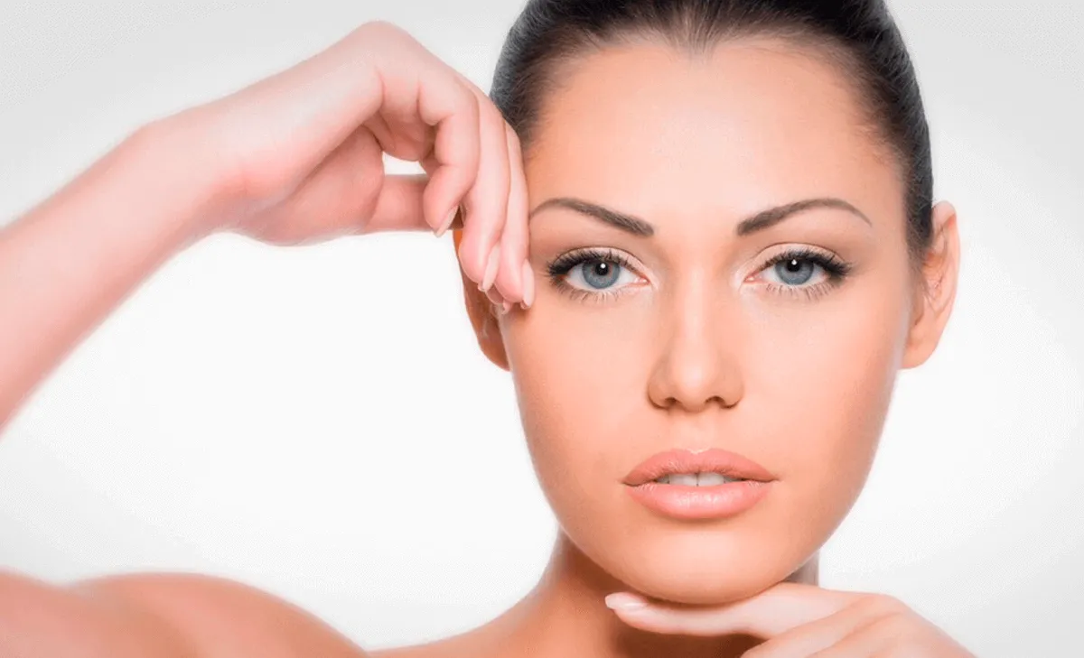mujer mostrando rostro con piel firme y rejuvenecida tras peeling facial en Murcia, tocando zona del contorno facial con resultado visible