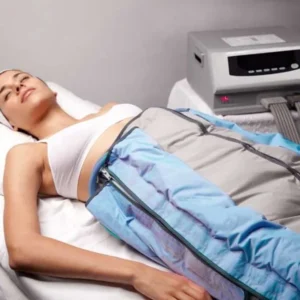 mujer relajada recibiendo tratamiento remodelante corporal con presoterapia en piernas usando botas de compresión azules en centro estético